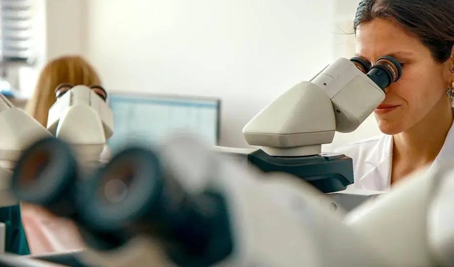 Una investigadora observa una muestra a trav&eacute;s del microscopio